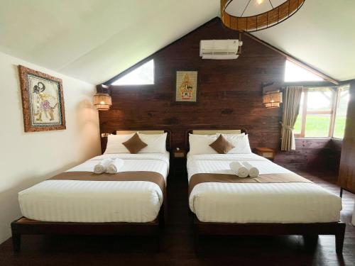 a bedroom with two beds in a room at The Phalosaa Villa in Ngaglik