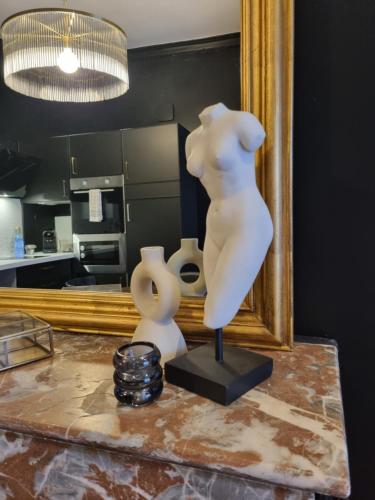 a statue of a woman on a table in front of a mirror at L'appartement d'Eugène in Auxerre