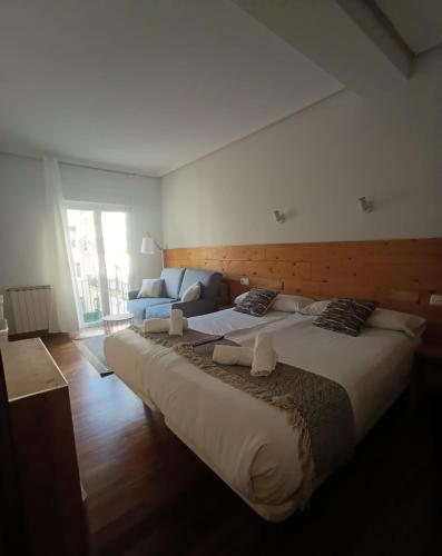 a large bed in a room with a large window at Pensión Urkia in Donostia-San Sebastián