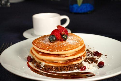 a plate with a stack of pancakes with berries on it at Courtyard by Marriott Mexico City Toreo in Mexico City
