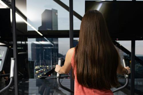 a woman looking out of a window at a city at Courtyard by Marriott Mexico City Toreo in Mexico City