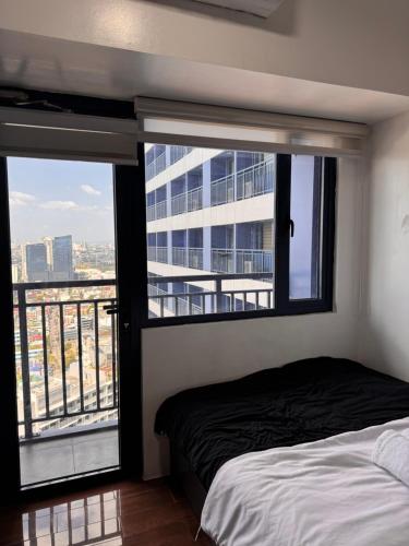a bedroom with a bed and a large window at The Air Residences #3724 in Manila