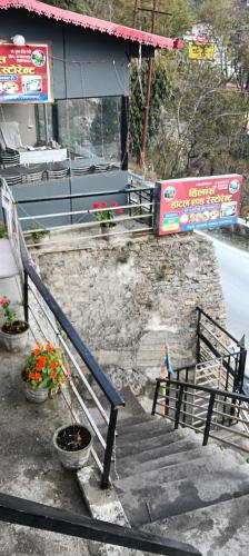 a set of stairs with potted plants in front of a building at Hilans Hotel and Restaurant in Ukhimath