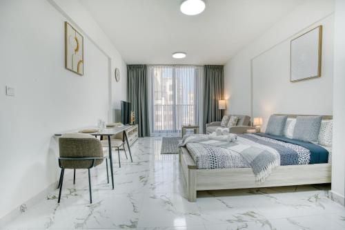 a bedroom with a bed and a table and chairs at Luxury Studio with Marina View Al Hamra Village in Ras al Khaimah
