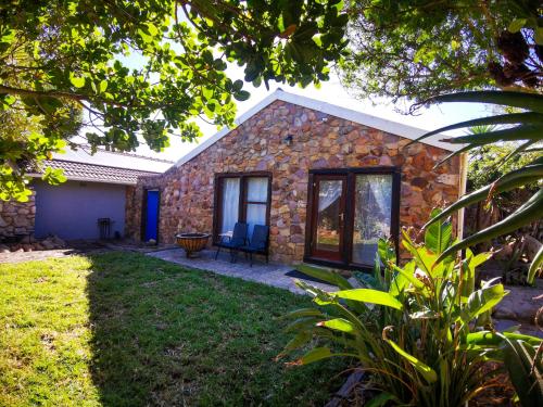 a stone house with two chairs in a yard at 29 on Edward in Cape Town