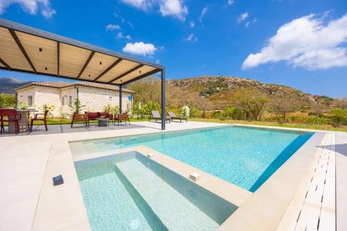 a swimming pool with a patio and a house at Villa Lilia in Katelios