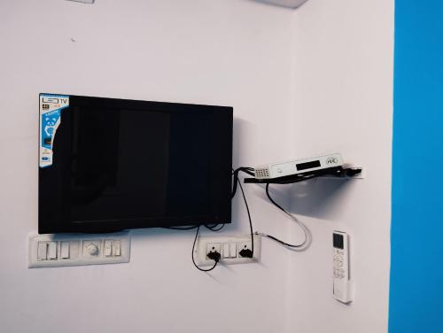 TV de pantalla plana con sistema de videojuegos en Hotel Sarovar Inn, en Ahmedabad