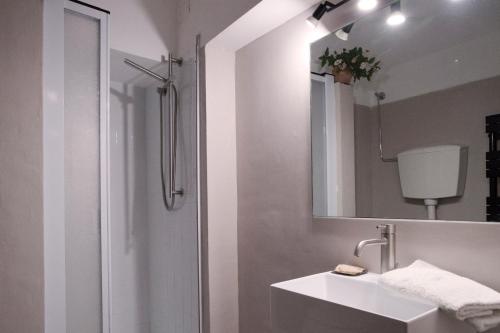a white bathroom with a sink and a mirror at SerenaHouse in Radicondoli