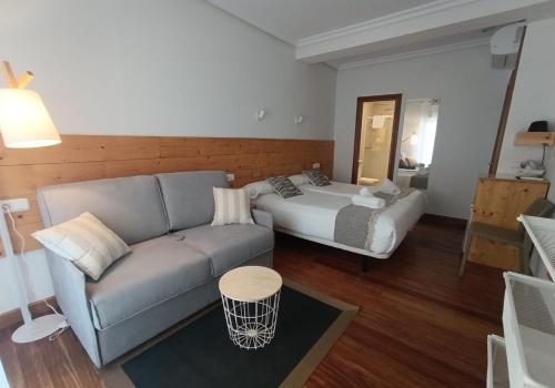 a living room with a couch and a bed at Pensión Urkia in Donostia-San Sebastián