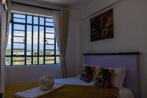 a bedroom with a bed with a large window at Urban 2 bedroom Nanyuki Mt Kenya Views in Nanyuki