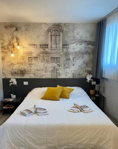 Un dormitorio con una gran cama blanca con almohadas amarillas. en My Palladio Suite, en Vicenza