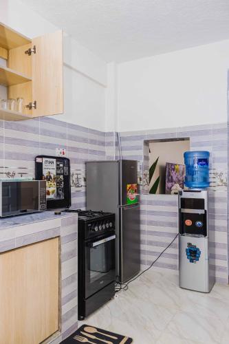 a kitchen with a stove and a refrigerator at Urban 2 bedroom Nanyuki Mt Kenya Views in Nanyuki