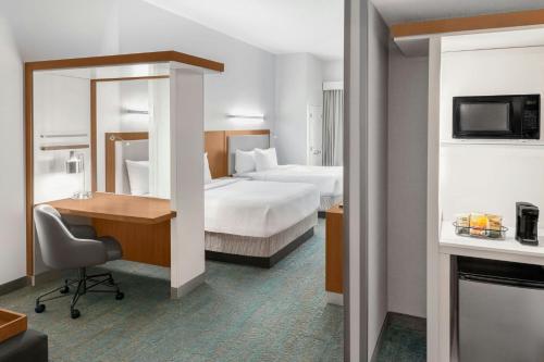 a hotel room with two beds and a desk at SpringHill Suites Detroit Auburn Hills in Auburn Hills