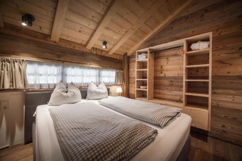sypialnia z łóżkiem w drewnianym domku w obiekcie IM WEIDACH Superior Chalets w mieście Leutasch