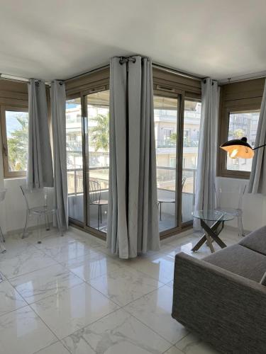- un salon avec de grandes fenêtres et un canapé dans l'établissement Résidence Graziella Appartement 521, à Juan-les-Pins