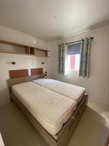un grand lit dans une chambre avec une fenêtre dans l'établissement Emplacement exceptionnel et rare sur la plage!, au Grau-dʼAgde
