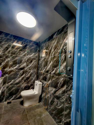 a bathroom with a toilet and a shower at Sun & Moon Homestay in Port Dickson