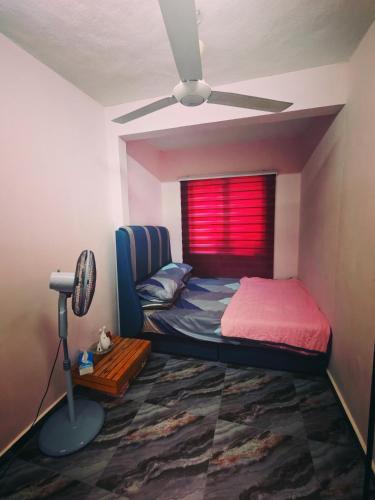 a bedroom with a bed and a ceiling fan at Sun & Moon Homestay in Port Dickson