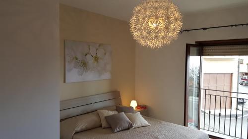 1 dormitorio con cama y lámpara de araña en Casa Sofia, en Caltabellotta