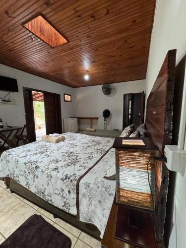 a bedroom with a bed and a wooden ceiling at Pousada Toca da Raposa in Cavalcante