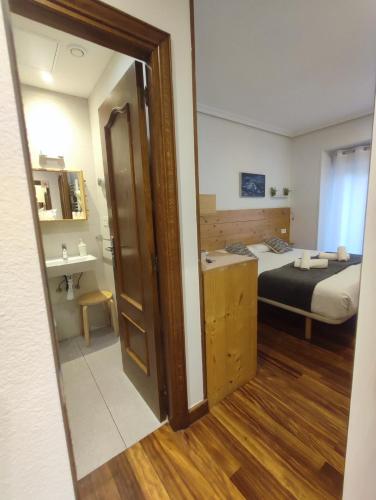 a small room with a bed and a room with a mirror at Pensión Urkia in Donostia-San Sebastián