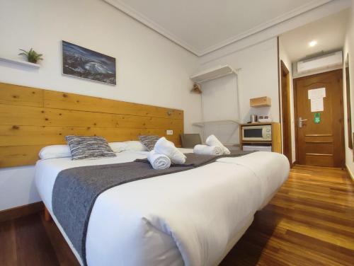 a bedroom with a large bed with a wooden headboard at Pensión Urkia in Donostia-San Sebastián