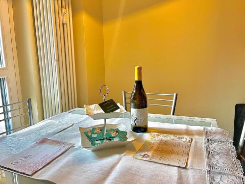 a bottle of wine sitting on top of a table at Rosso Apartment in Alba