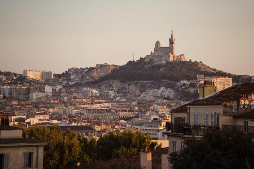a city with a castle on top of a hill at RockyPop Marseille Hôtel in Marseille