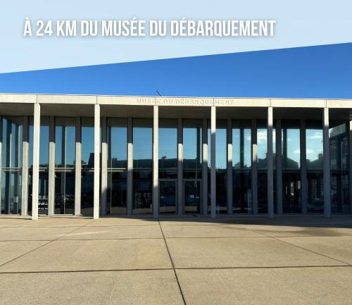 a building with a sign for a music dj detachment at Les mouettes Apt duplex indépendant dans maison spacieux petite vue sur mer des chambres belle terrasse aménagée en hauteur près Omaha Beach et Bayeux 800 m plage et 300 m superette in Vierville-sur-Mer
