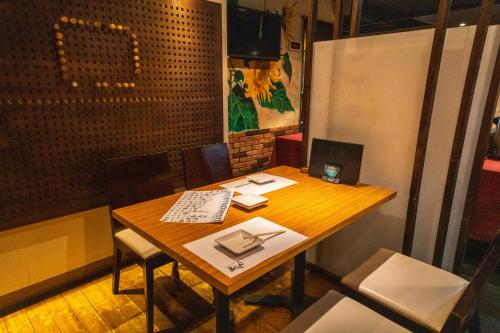 a wooden table with chairs and a laptop on it at Ramada Encore by Wyndham Amagasaki in Amagasaki