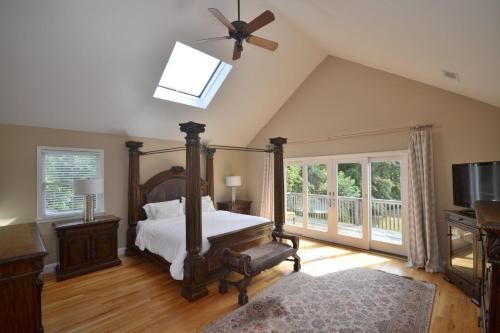 una camera da letto con un letto e un ventilatore a soffitto di Villa Isaiah - Southampton Luxury Estate a Southampton