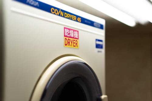 a close up of a washing machine with a sign on it at Ramada Encore by Wyndham Amagasaki in Amagasaki