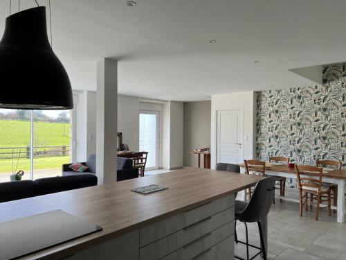 une cuisine et un salon avec une table et des chaises dans l'établissement Logement infependant, à Crennes-sur-Fraubée