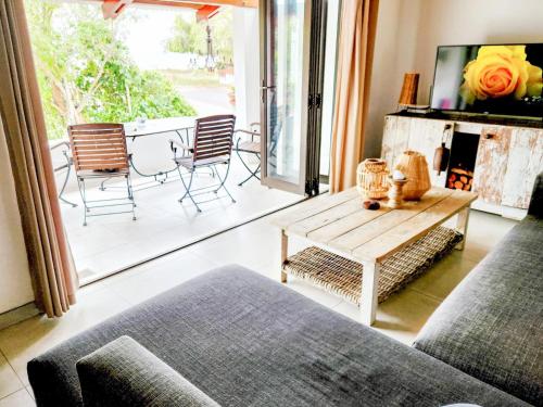a living room with a couch and a table at Saint Anna Beach House in St Helena Bay