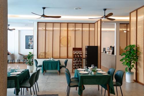a dining room with green tables and chairs at Smile Boutique Hotel By EHM in Phnom Penh