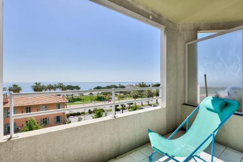 une chaise bleue sur un balcon avec vue sur l'océan dans l'établissement T3 avec terrasse vue sur mer à 400m de la plage, à Nice