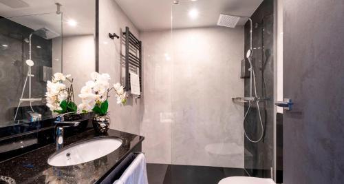 a bathroom with a sink and a shower at PLAZA Hotel Bruchsal in Bruchsal