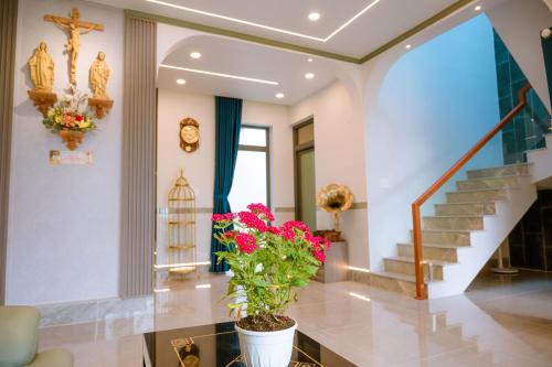 a living room with a staircase and a potted plant at Cherry Villa - Biệt Thự View Biển Cao Cấp Lagi Bình Thuận in La Gi