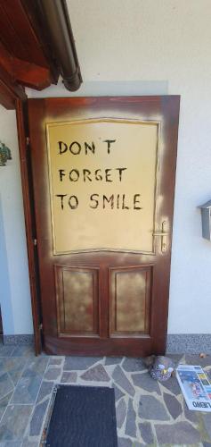 a door with a sign on it that says dont forget to smile at Bella Hiša in Sromlje