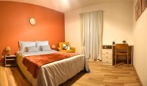 una camera da letto con un letto con una parete arancione di Maison Premium Hyper Calme - Joliment décorée avec vue dégagée - Jacuzzi Chauffé - Salle de jeux - Proche de toutes commodités a Montélimar