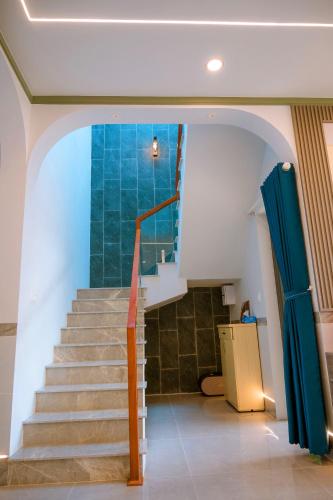a staircase in a house with a blue wall at Cherry Villa - Biệt Thự View Biển Cao Cấp Lagi Bình Thuận in La Gi