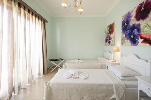 a white room with two beds and a couch at White House Apartment in Kalami