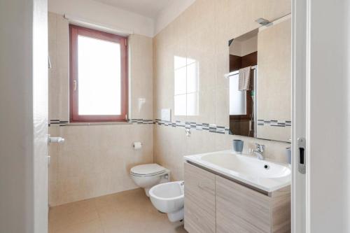 a white bathroom with a toilet and a sink at Terrazza Giulia in Brindisi