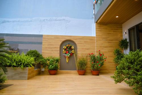 a hallway with potted plants and a wreath on a building at Cherry Villa - Biệt Thự View Biển Cao Cấp Lagi Bình Thuận in La Gi