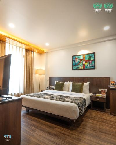 a bedroom with a large bed in a hotel room at Woodrock Luxury Boutique Hotel in Manāli