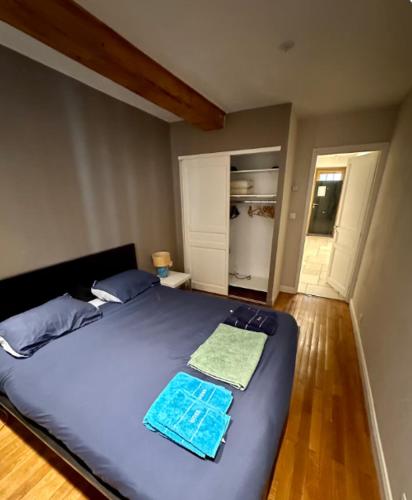 une chambre avec un grand lit avec des draps bleus dans l'établissement Appartement moderne, Lyon 6ème, à Lyon