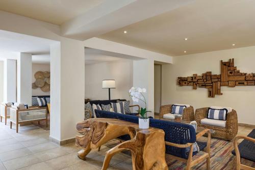 a living room with a table and chairs at Waves Resort & Spa, Barbados, An Autograph Collection All-Inclusive Resort in Saint James