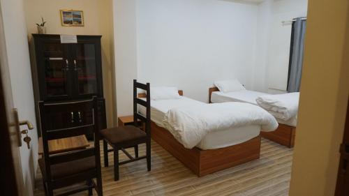 a bedroom with two beds and a chair in it at Kathmandu home in Kathmandu