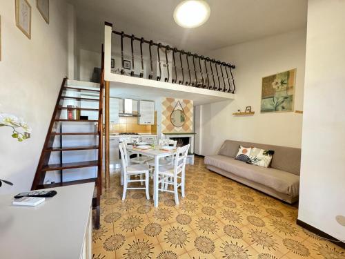 a living room with a table and a loft bed at Casa di Giggia in Marina di Cerveteri