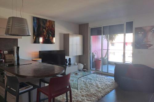 un salon avec une table à manger et un salon dans l'établissement Beautiful T2 with pool - near beach, à Palavas-les-Flots